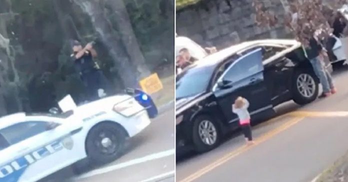 toddler-walks-towards-police-hands-up toddler walks towards police hands up
